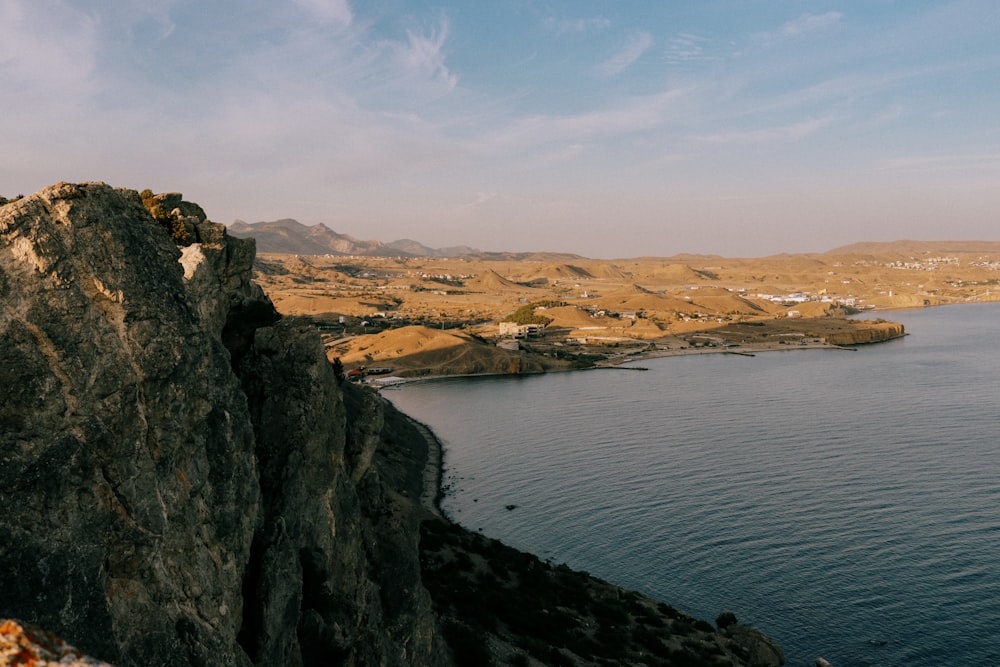 a person standing on a cliff overlooking a body of water