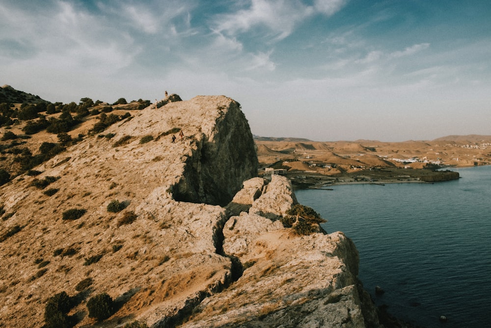 a large body of water near a rocky cliff