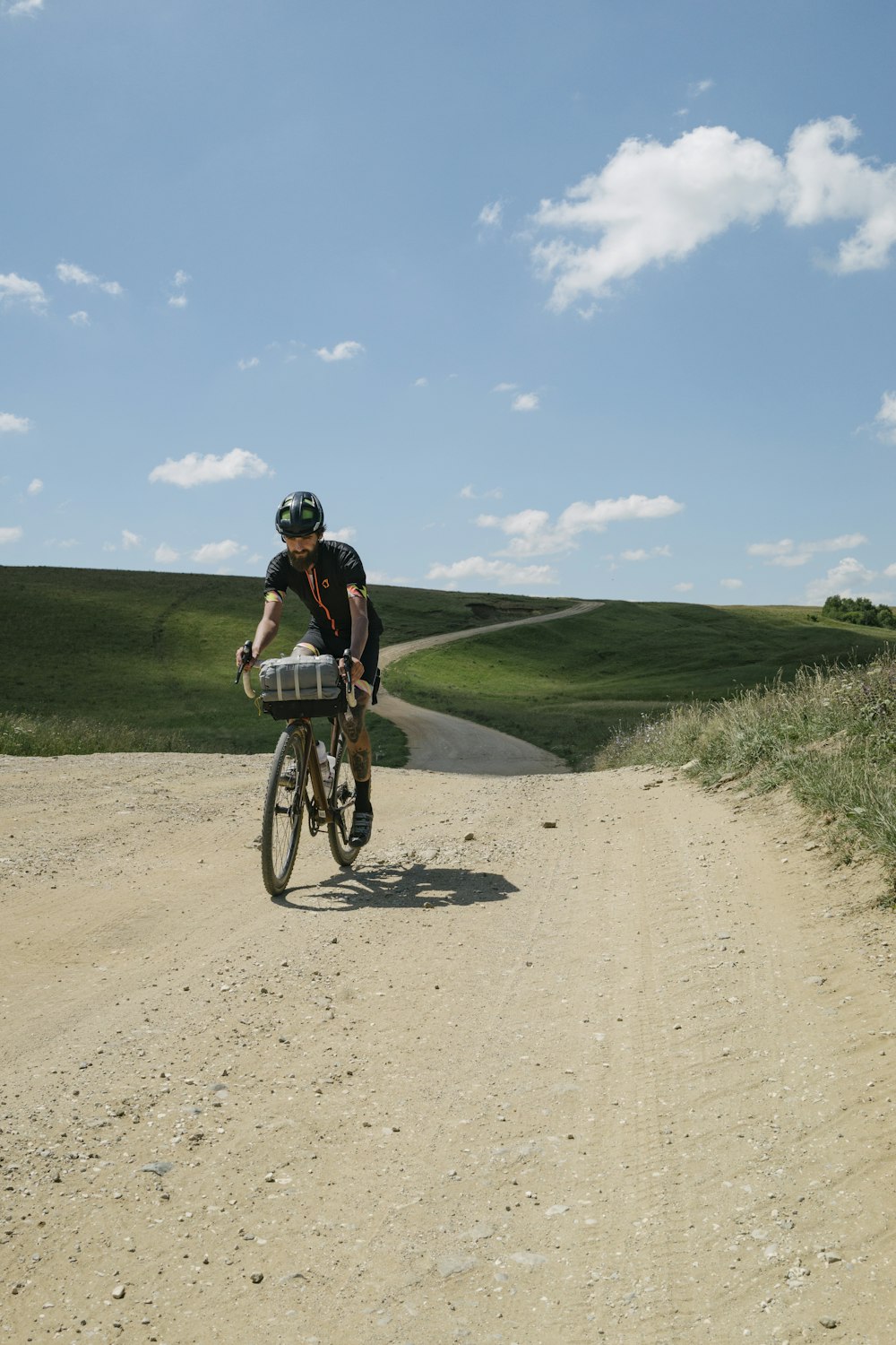 a man riding a bike down a dirt road