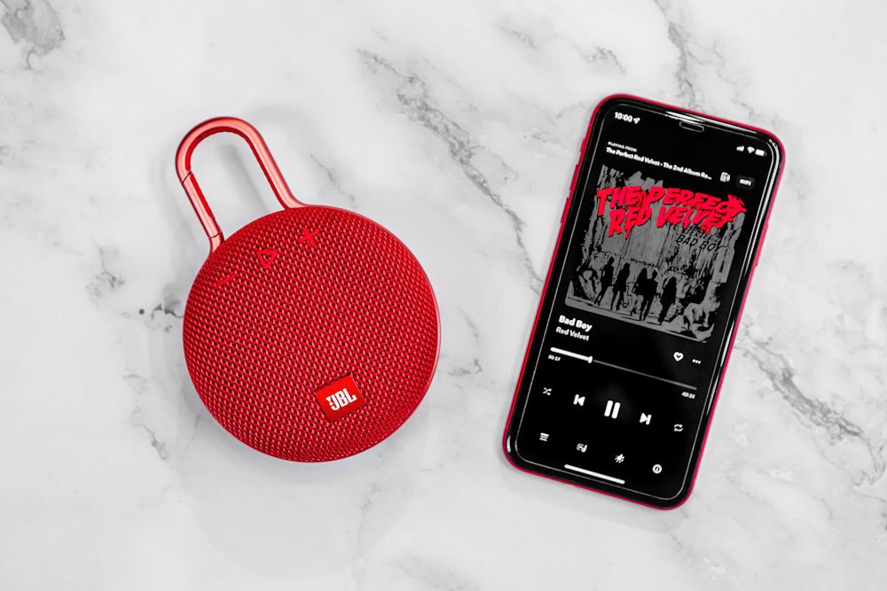 a red portable speaker next to an mp3 player