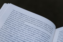 A close-up view of an open book with text in Italian. The pages are slightly curved, and the focus is on the text, making some words clear while others are slightly out of focus.