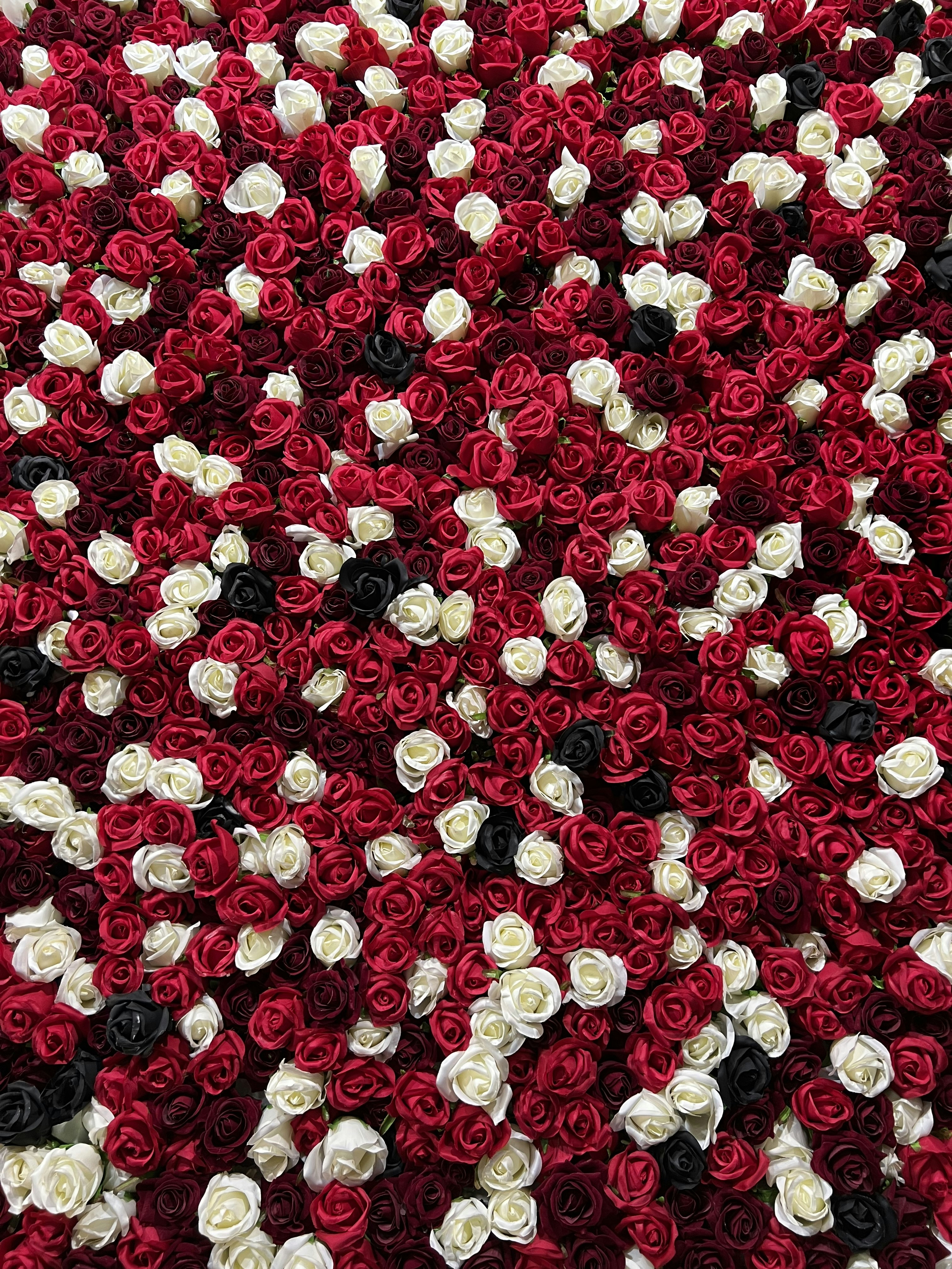 ein Strauß roter und weißer Blumen auf einem Tisch