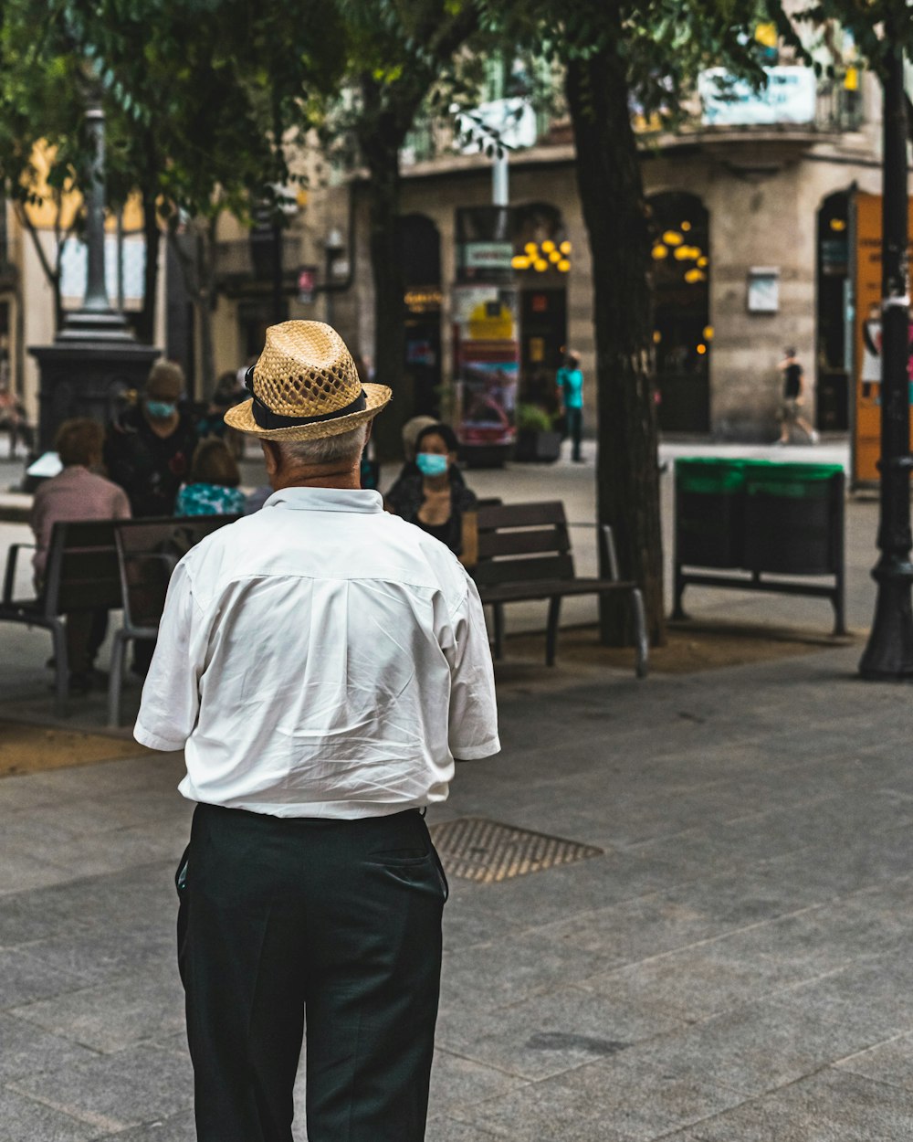 a man in a hat is walking down the street