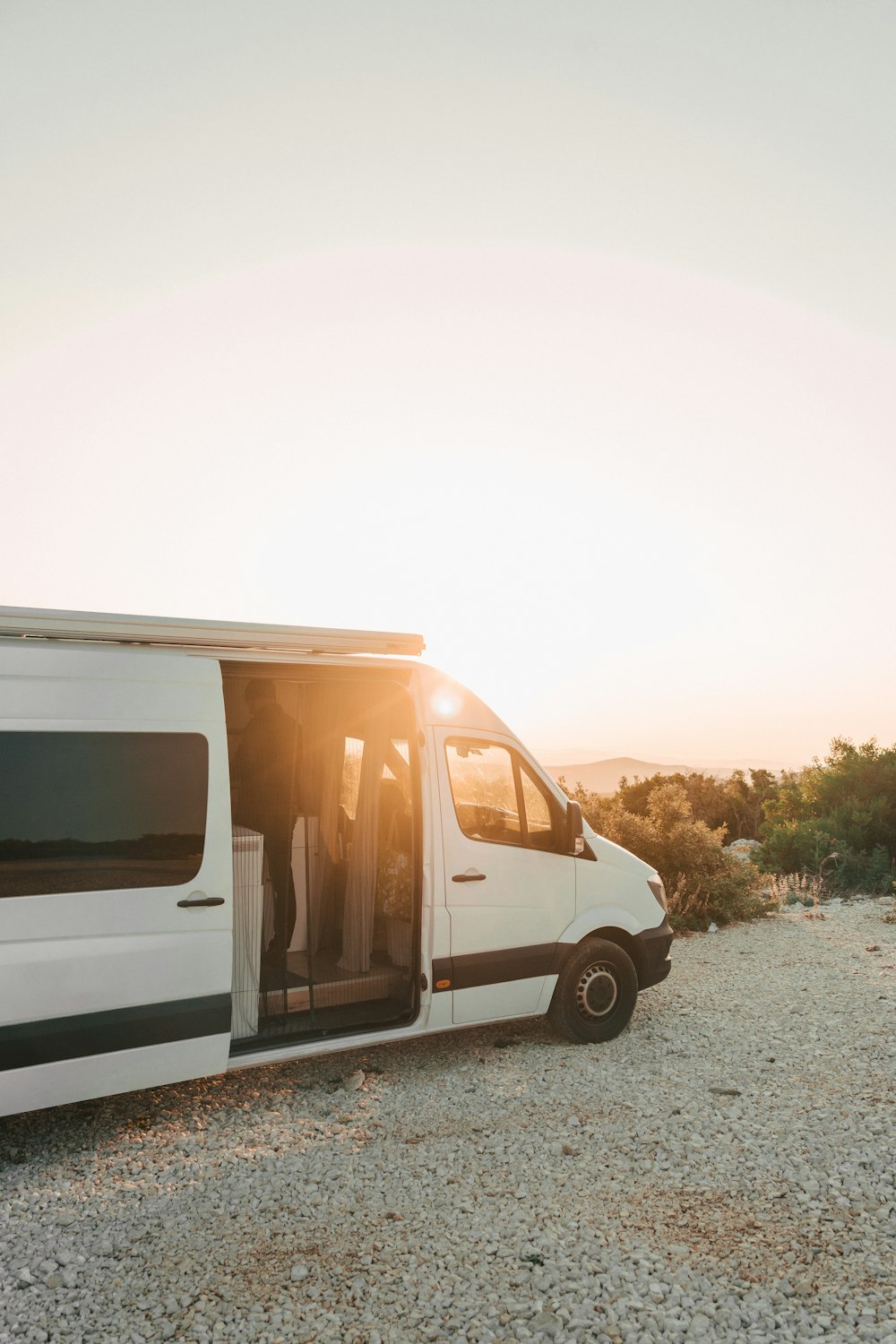 a white van parked on top of a gravel field