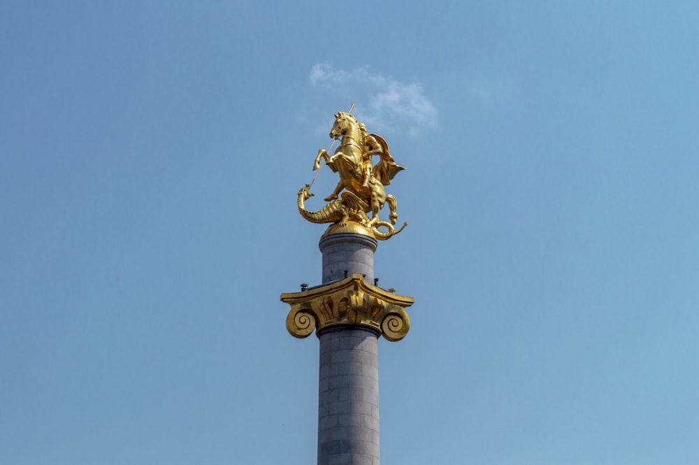 a golden statue on top of a tall pillar