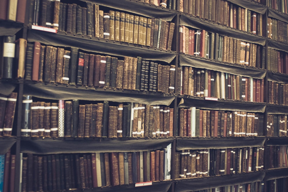 a bookshelf filled with lots of books in a library