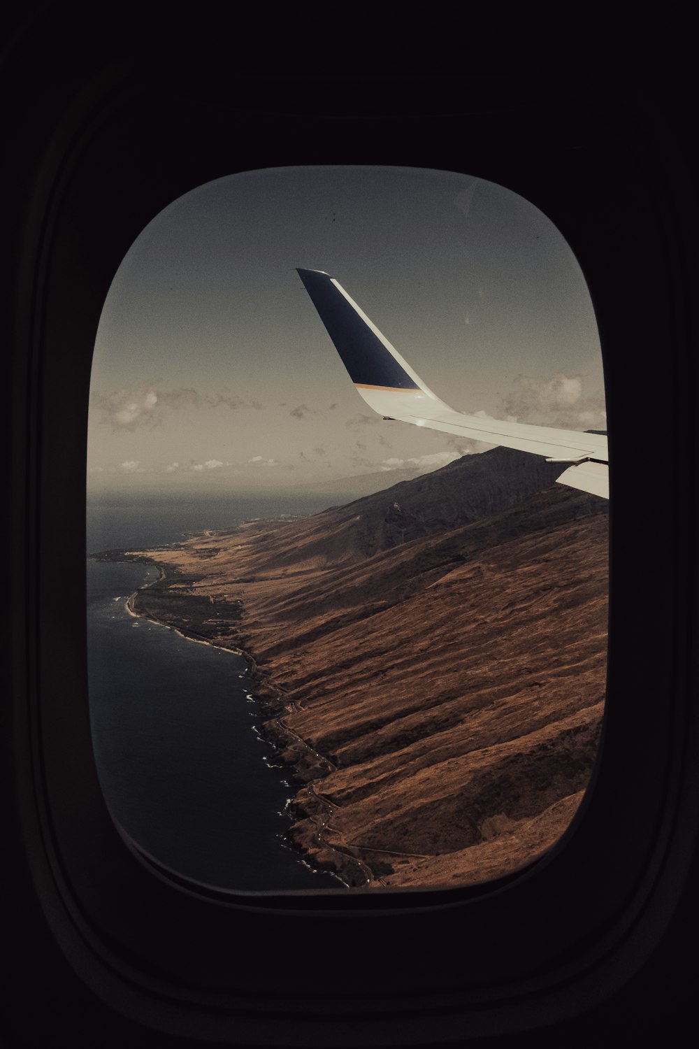 an airplane wing flying over a body of water