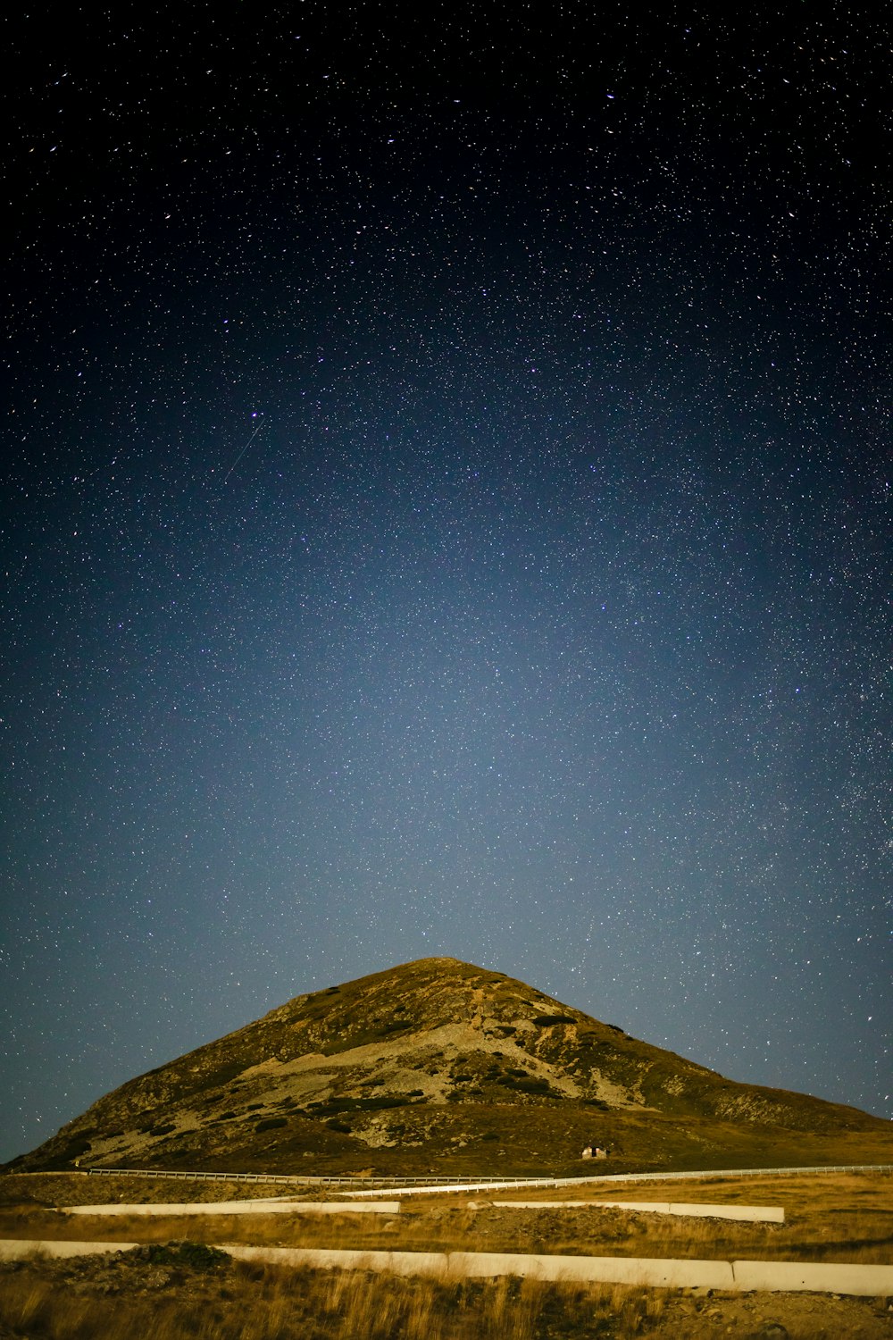 a hill with a few stars in the sky