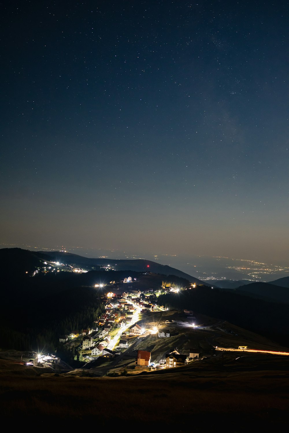 a night time view of a town and mountains