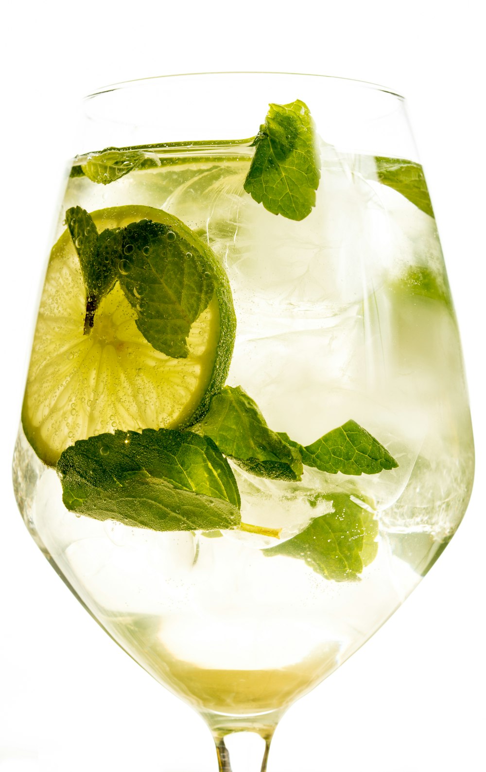a glass of water with a lime and mint garnish