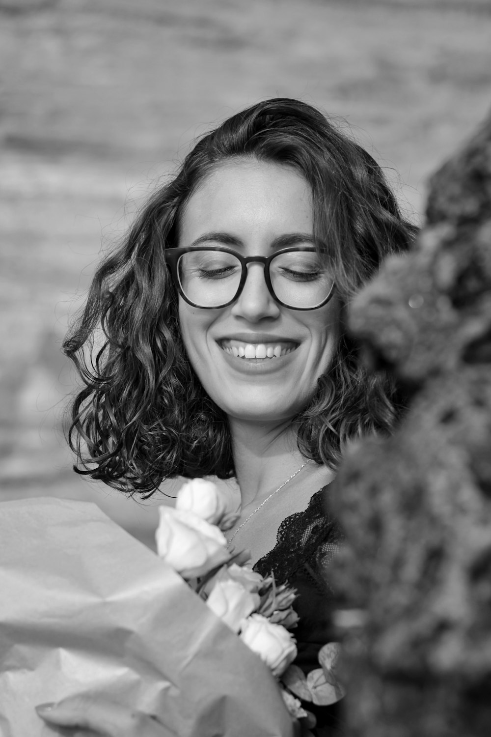 a woman wearing glasses holding a bouquet of flowers