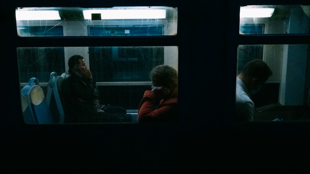 a couple of people sitting on a train next to each other