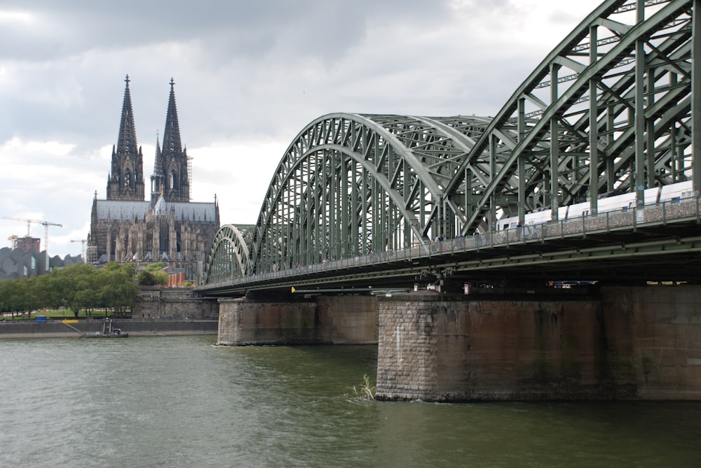 a bridge over a river with a cathedral in the background