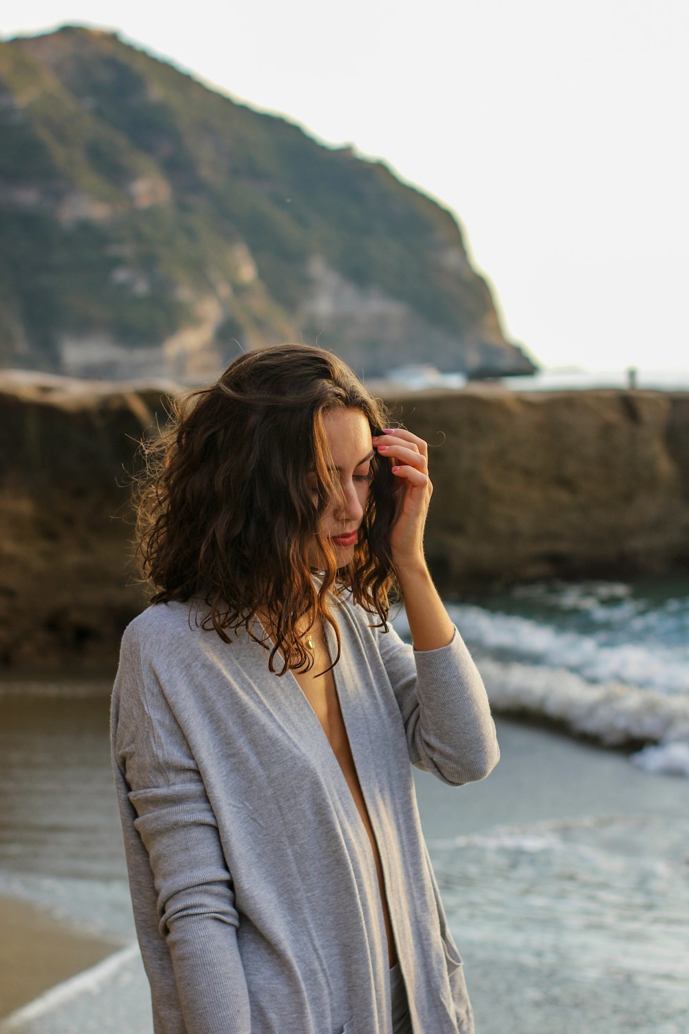 a woman standing on a beach next to the ocean