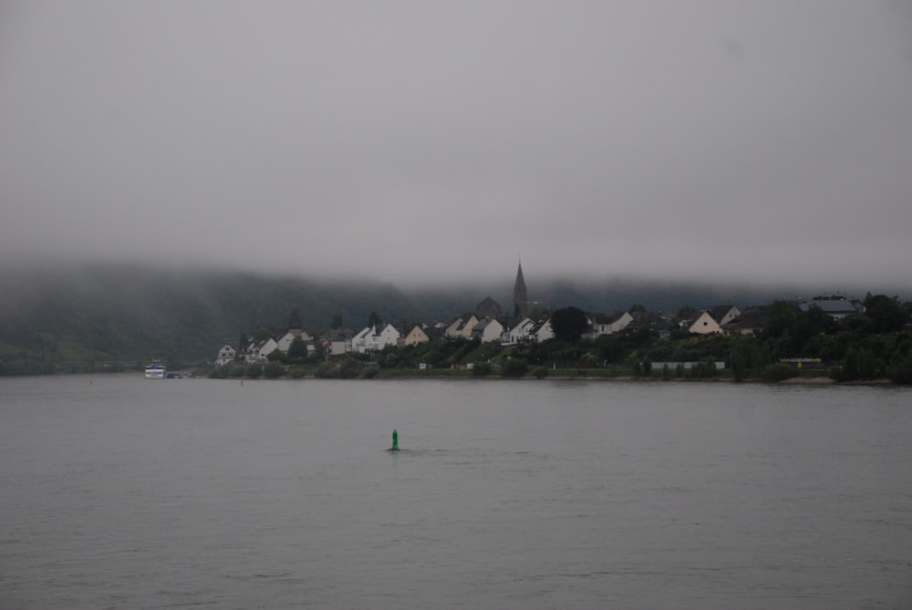 a body of water with houses on a hill in the background