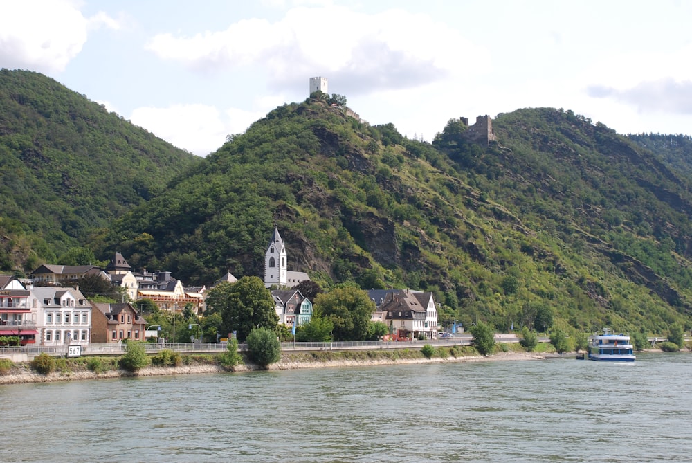 a small town on the side of a mountain next to a body of water