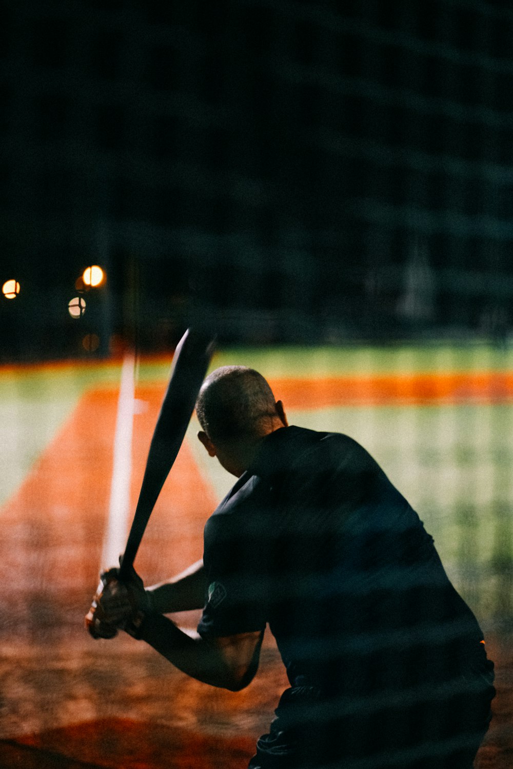 Un homme tenant une batte de baseball sur un terrain de baseball