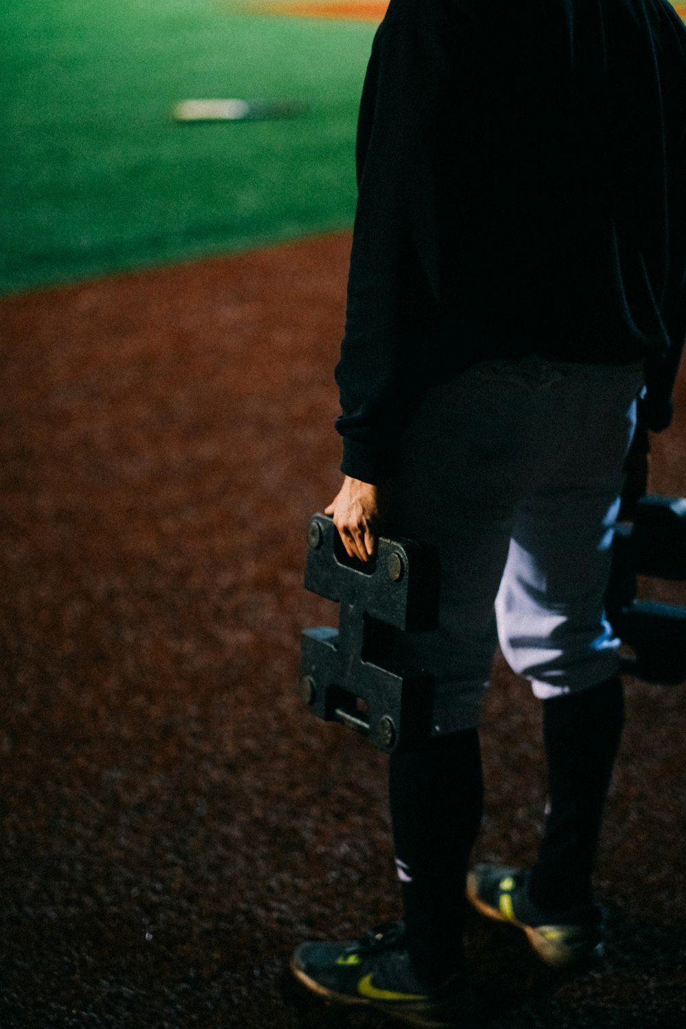 a man standing on a baseball field holding a bat