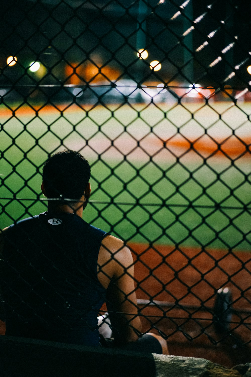 a man sitting on a bench watching a baseball game