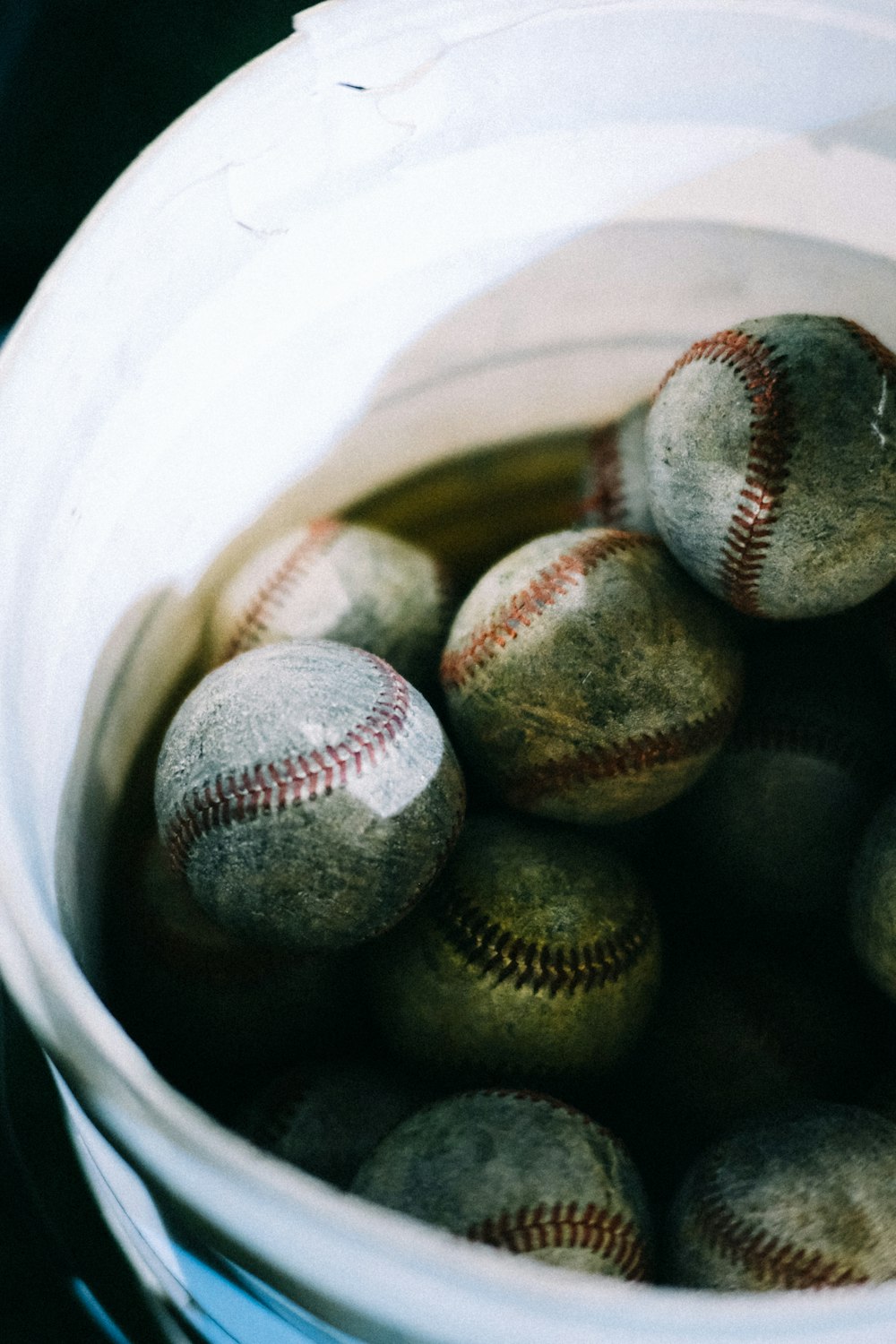 un seau rempli de balles de baseball posé sur une table