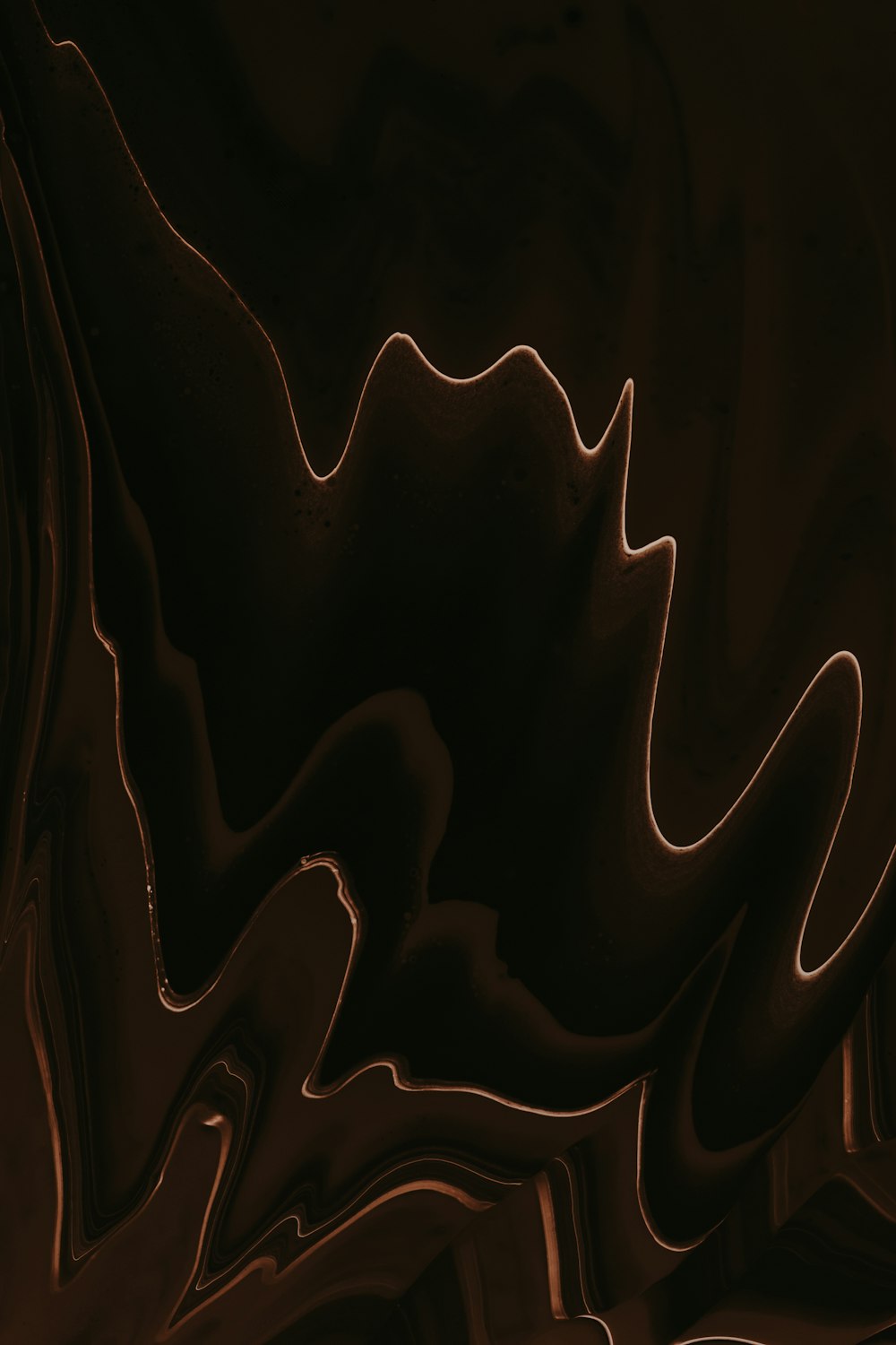 a black and brown abstract background with wavy lines