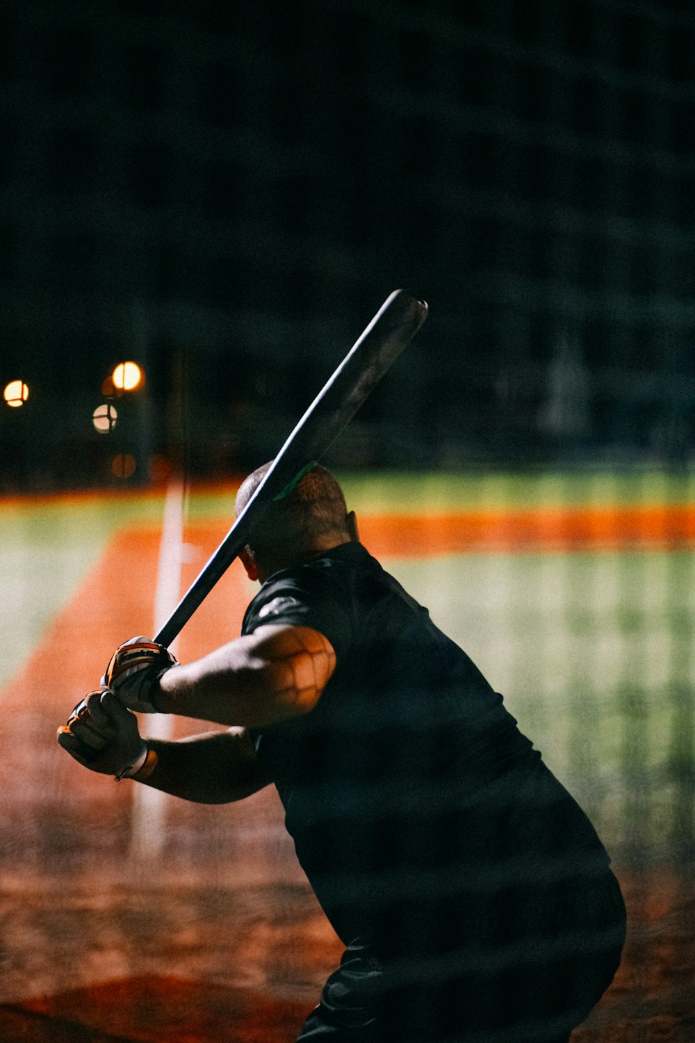 um homem segurando um taco de beisebol em cima de um campo de beisebol