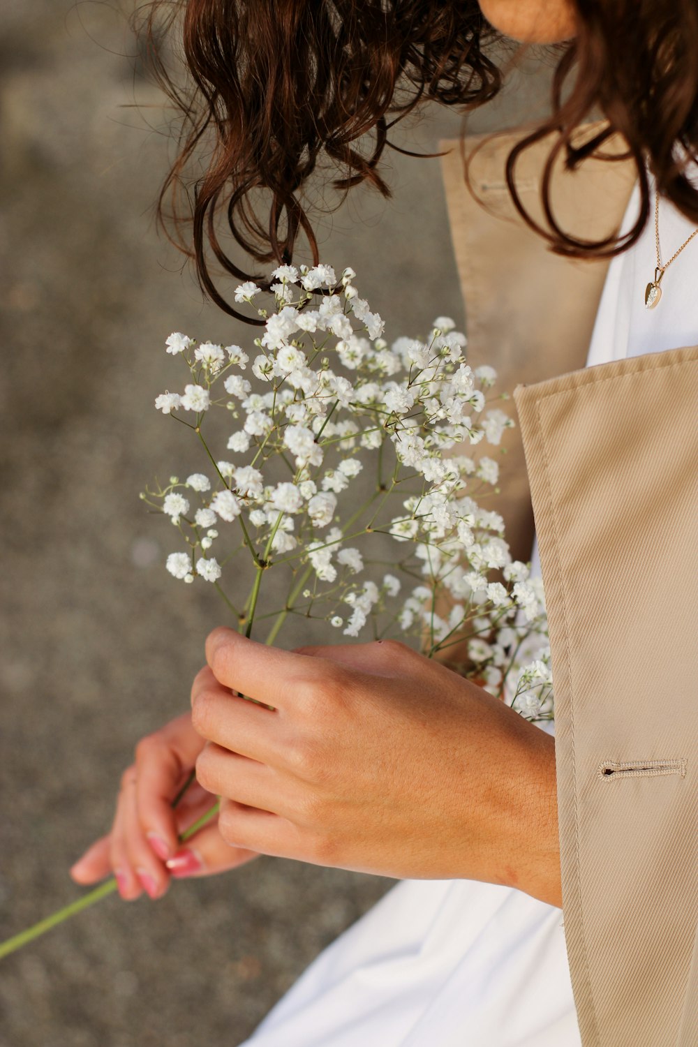 a woman holding a bouquet of white flowers