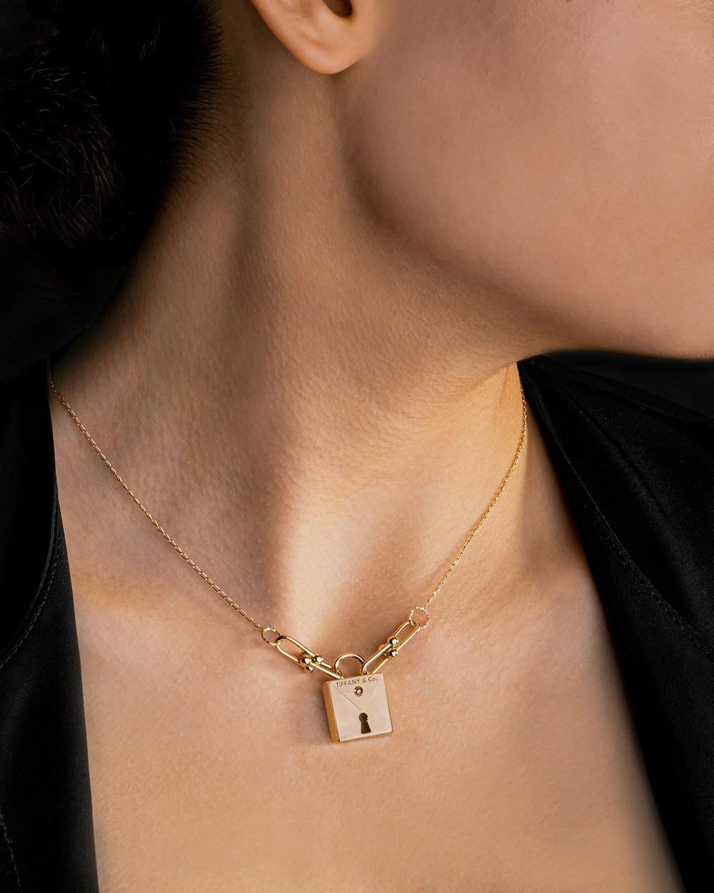 a woman wearing a necklace with a lock on it