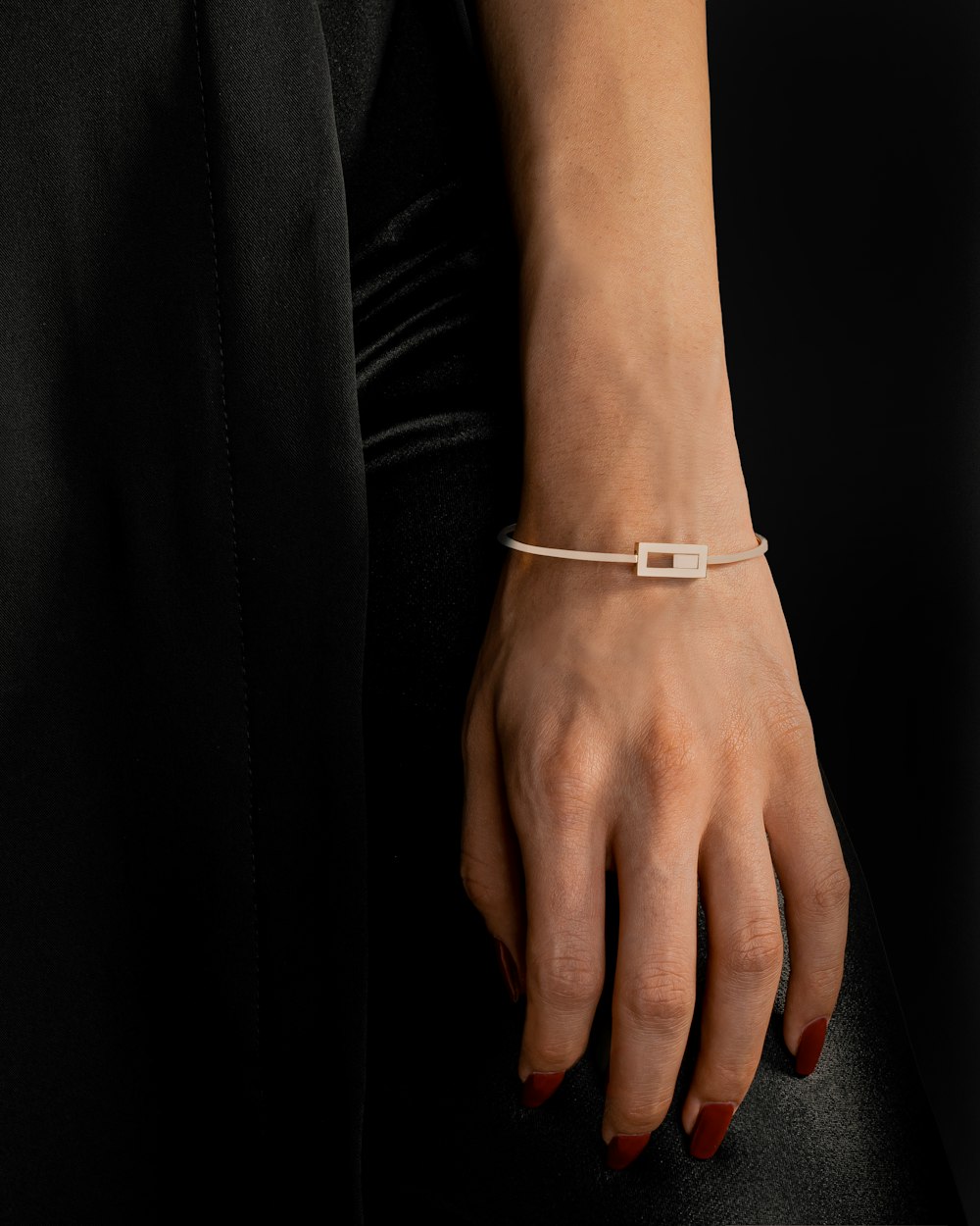 a woman's hand wearing a thin bracelet