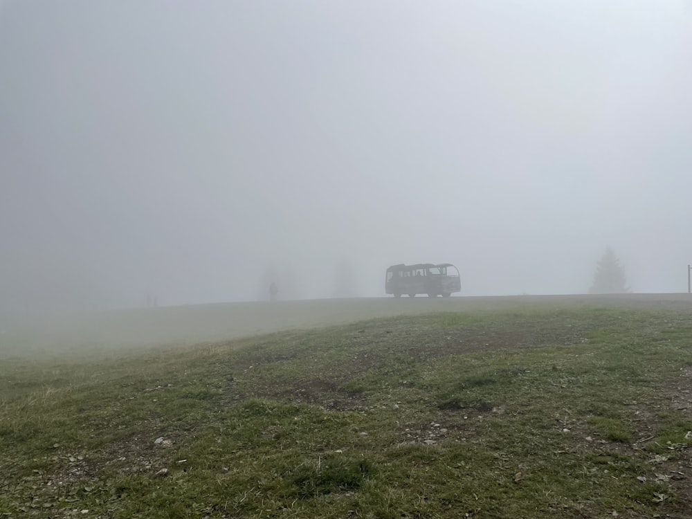 a bus driving on a foggy day in a field