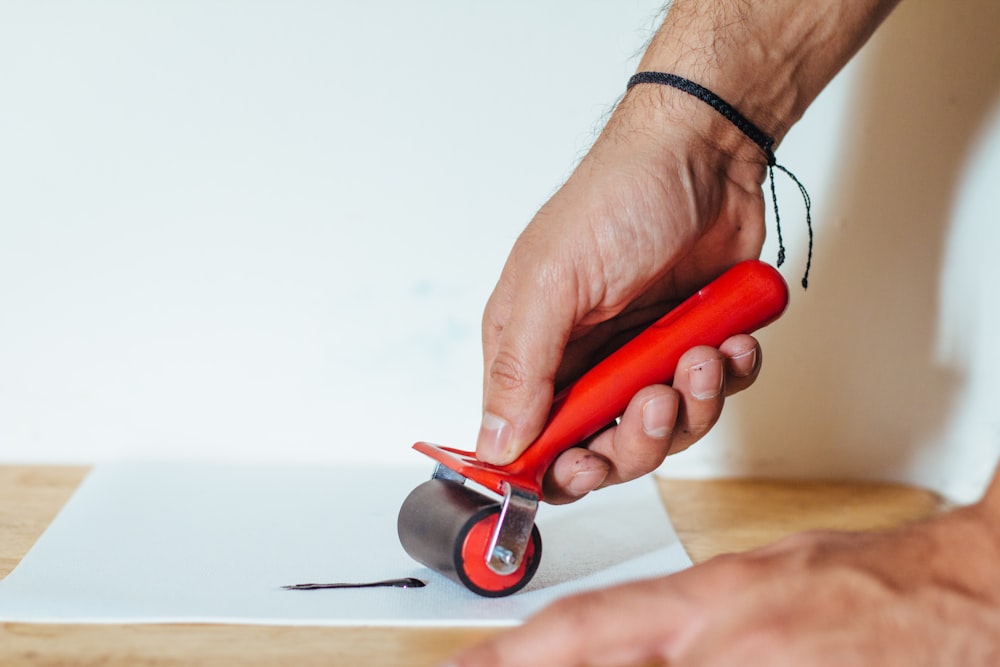 a person is using a pair of scissors to cut a piece of paper