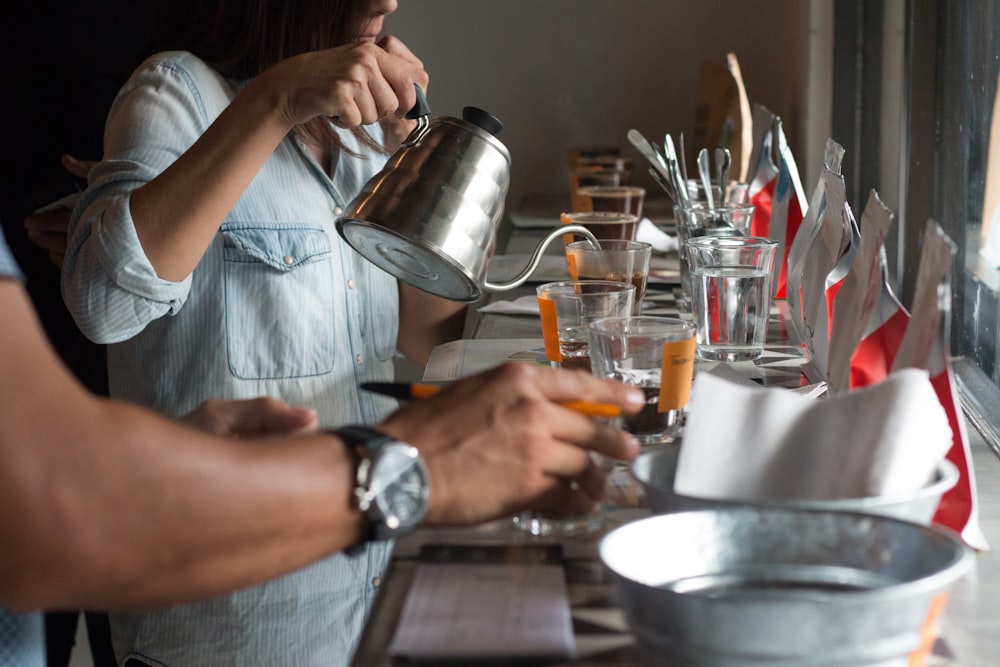 a man and a woman standing at a table with cups