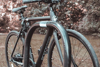 A close-up of a sleek bicycle equipped with a bright helmet and sturdy lock, set against a city backdrop.