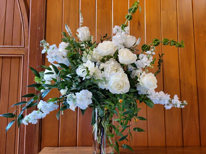 Luxurious floral arrangement with roses and greenery in a stylish glass vase.