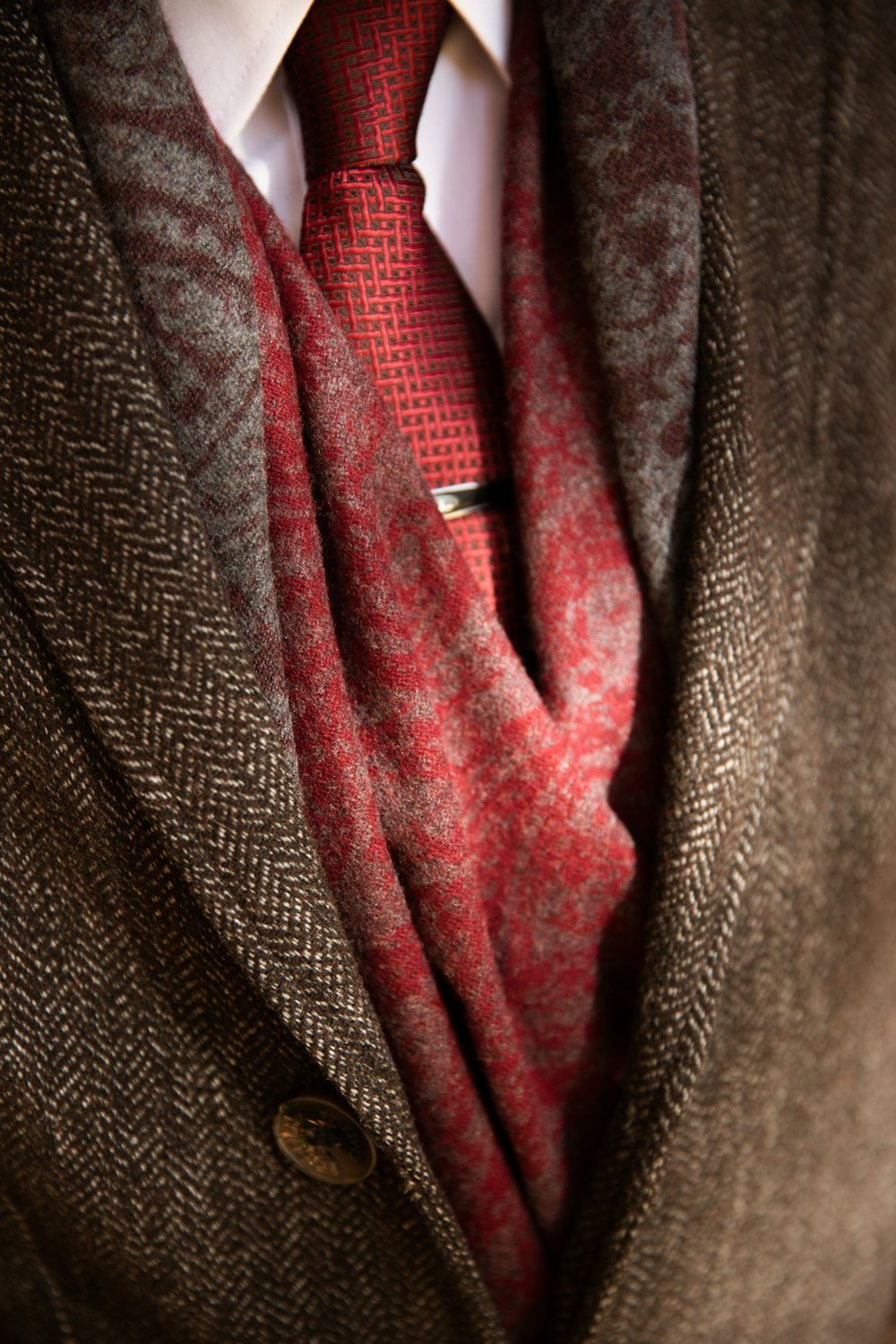 a man wearing a red tie and a brown jacket