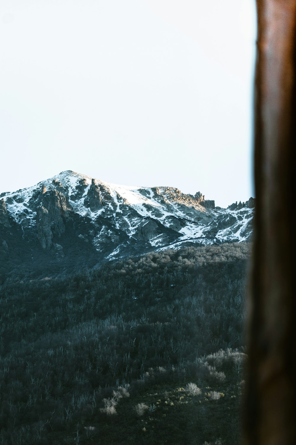 a view of a snowy mountain from a window