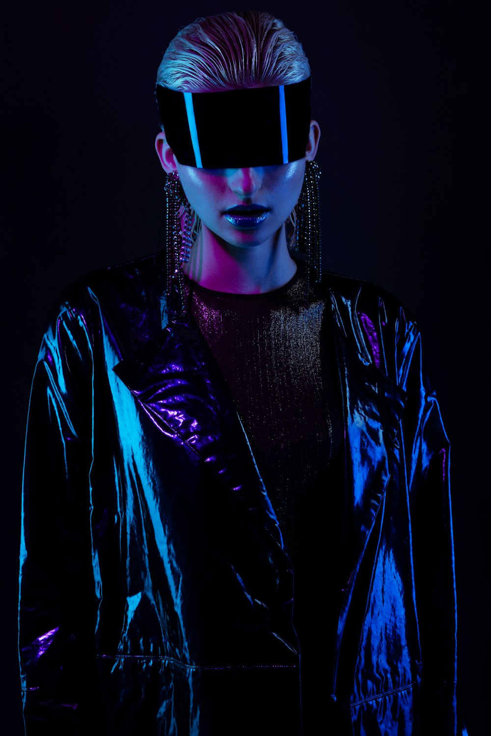 a woman in a shiny jacket with a blindfold over her eyes