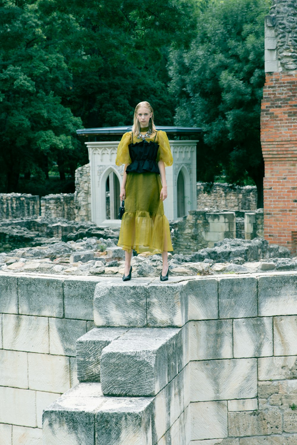 a woman standing on top of a stone wall