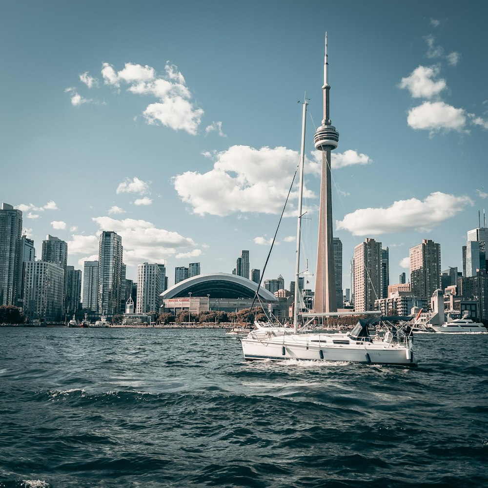 a sailboat in a body of water with a city in the background