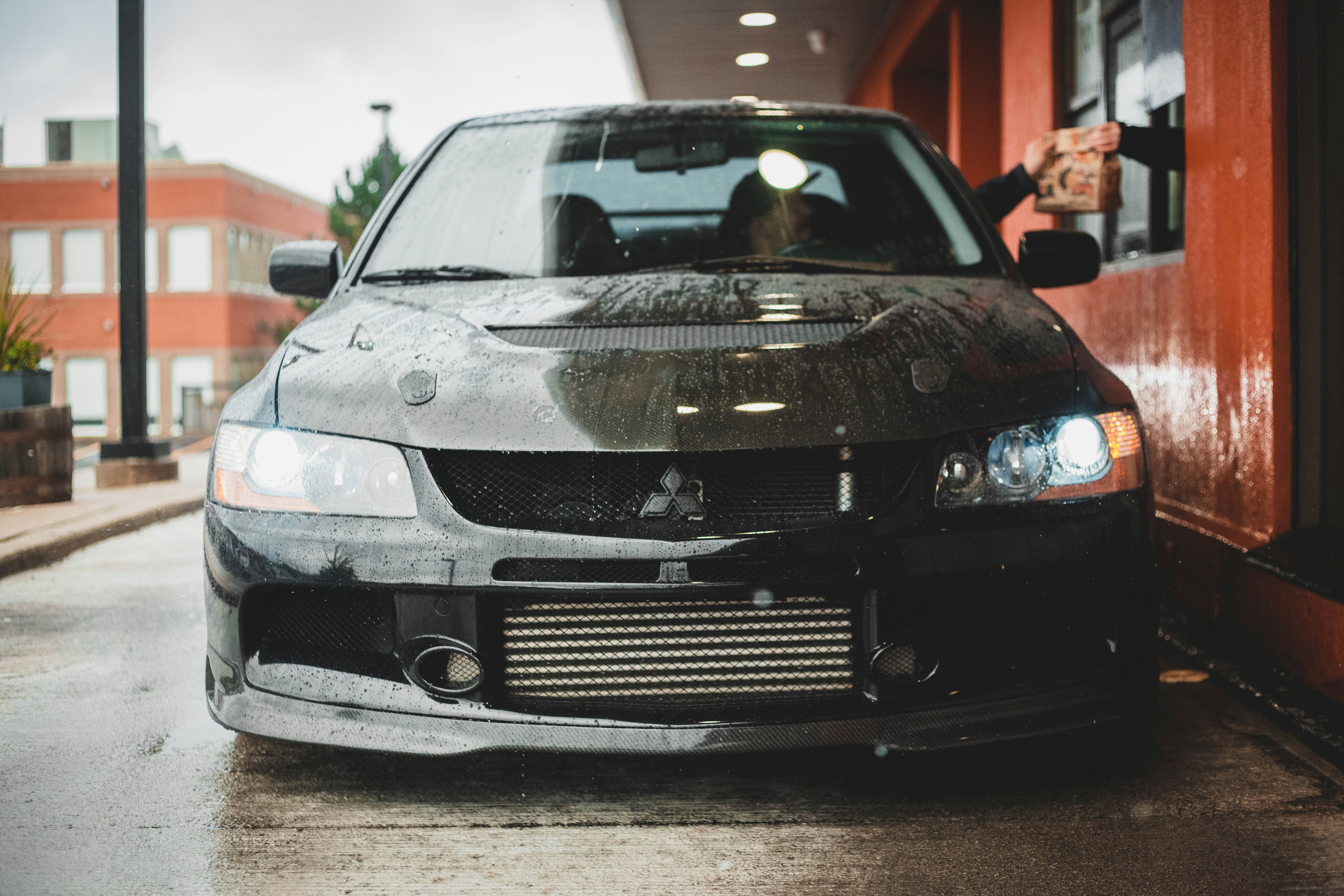 a car parked in front of a building on a rainy day