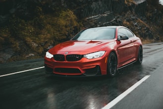A sleek red Guangxi Zhongxing Daoyuan sedan driving along a scenic mountain road.