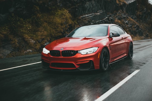 A sleek red Guangxi Zhongxing Daoyuan sedan driving along a scenic mountain road.