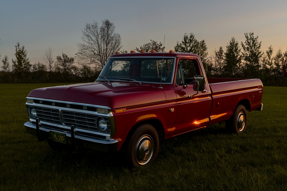 a red pick up truck parked in a field
