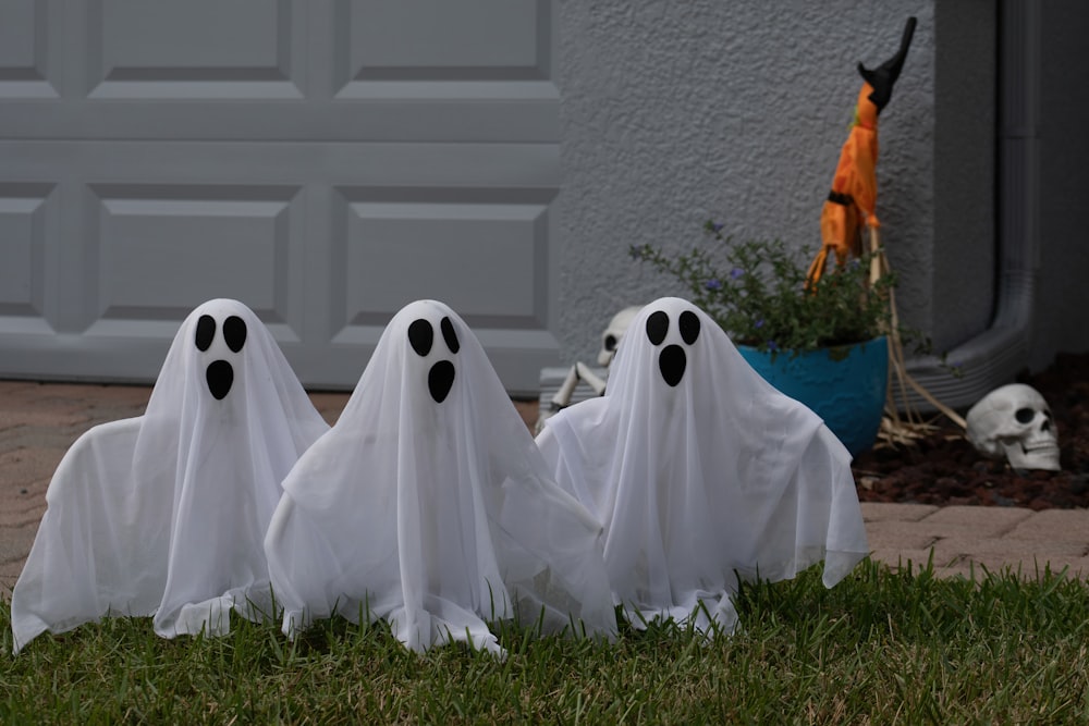 three ghost statues in front of a garage