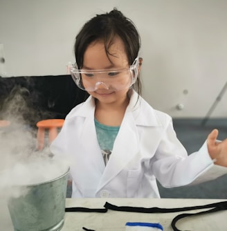 a little girl wearing a white lab coat and goggles