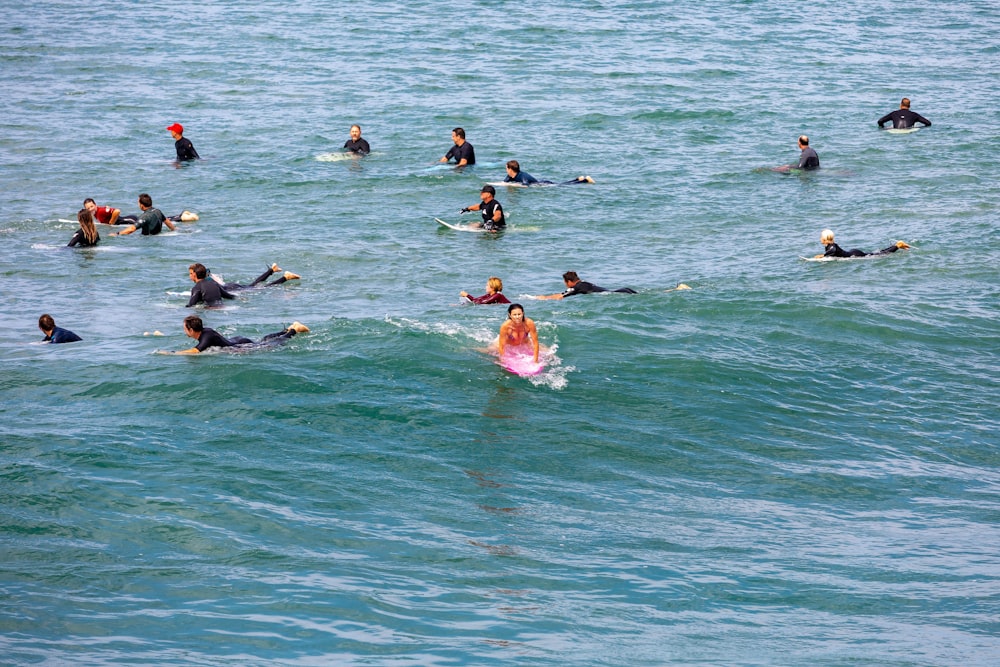 a group of people riding surfboards on top of a wave