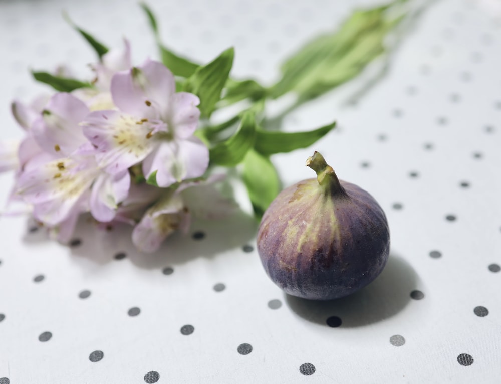 a close up of a figurine and flowers on a table