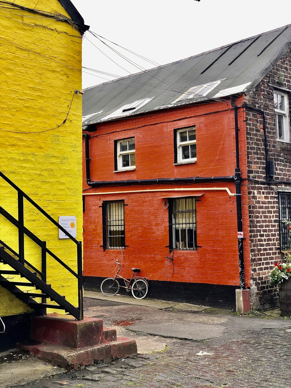 a red and yellow building with a bicycle parked in front of it