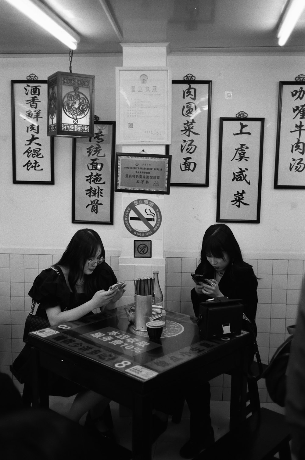 a couple of women sitting at a table next to each other