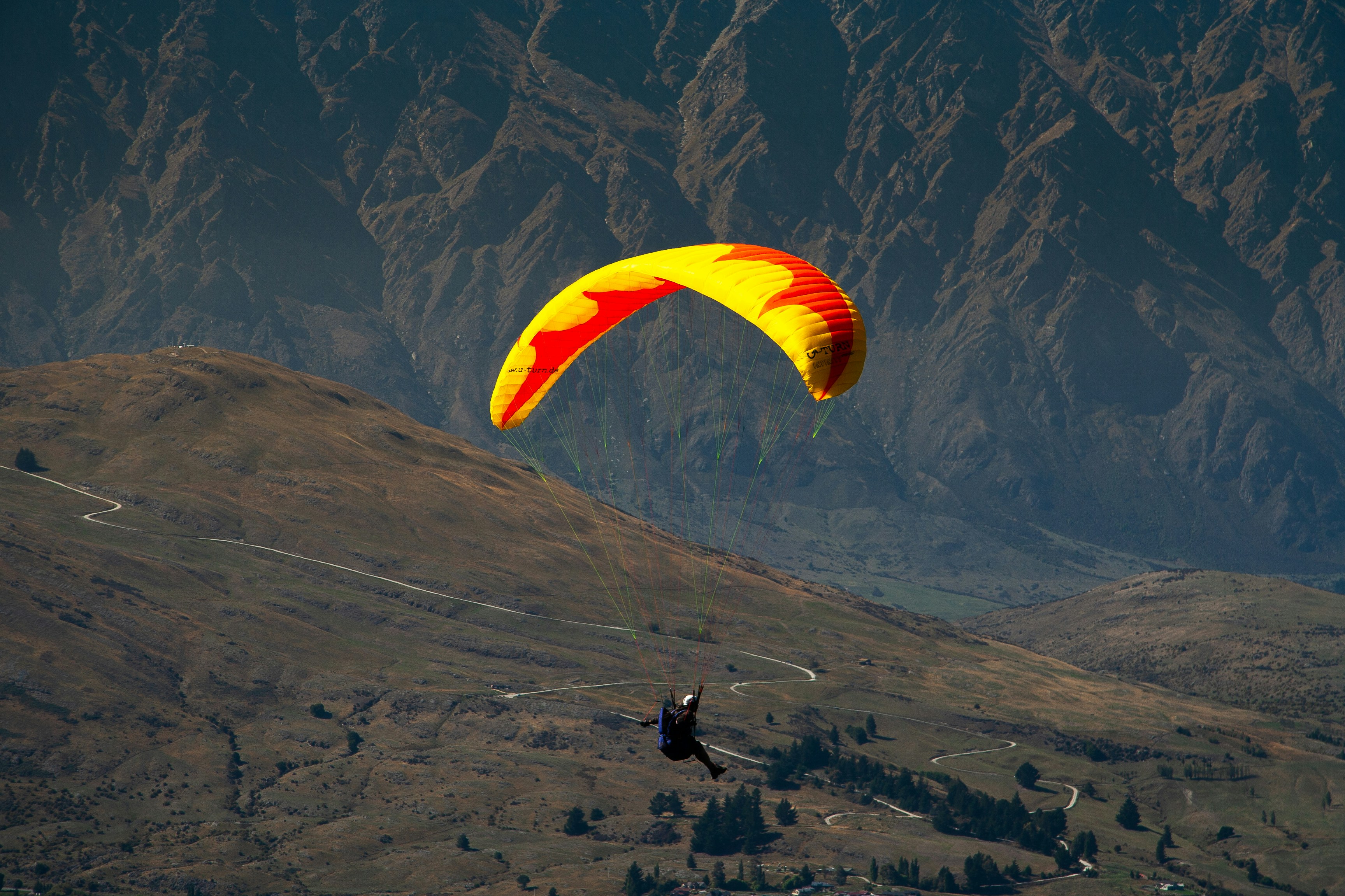 a person is parasailing over a mountain range